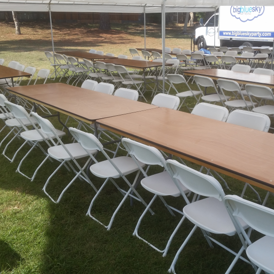 8 ft Rectangular tables for rent with white folding chairs.